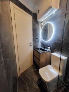 un bagno con un water, un lavandino e uno specchio di Seabreeze by Matteo a San Pawl il-Baħar Altre 6 foto