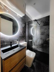 un bagno con lavandino, WC e specchio di Seabreeze by Matteo a San Pawl il-Baħar