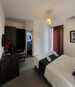 una camera da letto con un letto, una scrivania e una televisione di Seabreeze by Matteo a San Pawl il-Baħar