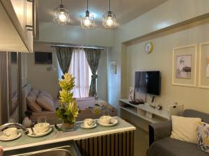 a living room with a couch and a table with dishes on it at Avida tower 1 L21 staycation condotel rm1002 in Iloilo City