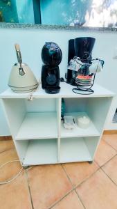 ein weißes Regal mit Geschirr und einer Lampe darauf in der Unterkunft Quinta Sarnadela - Spacious 3 bedroom house with mountain view in Oliveira do Hospital