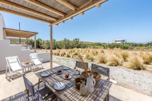 un patio con tavolo e sedie su un ponte di Relaxia Estate Naxos By KB Hospitality a Galini