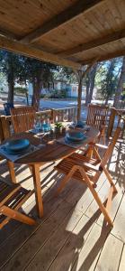 ein Holztisch und Stühle auf einer Holzterrasse in der Unterkunft Vomer Beachside Unit in Pakoštane