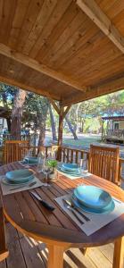 ein Holztisch mit Tellern und Weingläsern darauf in der Unterkunft Vomer Beachside Unit in Pakoštane