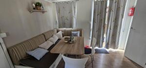 a living room with a table and a couch at Camping Units Vomer in Pakoštane