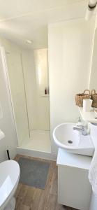 ein weißes Badezimmer mit Dusche und Waschbecken in der Unterkunft Vomer Beachside Unit in Pakoštane