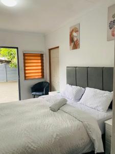 a bedroom with a large white bed and a chair at Linies guest house northmead in Benoni