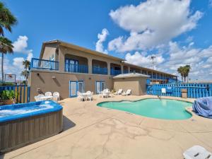a resort with a swimming pool and a building at Alister Square Inn in Port Aransas