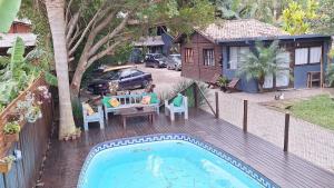 a backyard with a swimming pool and a house at Apartamento Residencial Recanto Da Ferrugem in Garopaba