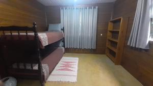 a bedroom with two bunk beds and a window at Apartamento Residencial Recanto Da Ferrugem in Garopaba
