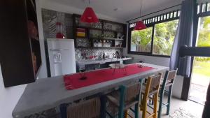 a kitchen with a large island with a red counter top at Apartamento Residencial Recanto Da Ferrugem in Garopaba