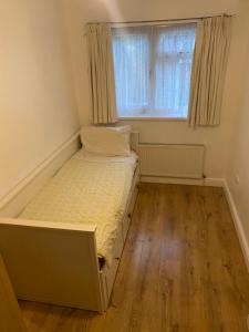 ein kleines Schlafzimmer mit einem Bett und einem Fenster in der Unterkunft Firs Drive in Cranford + 8 Fotos