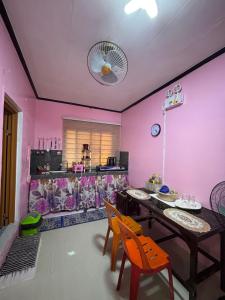 Un comedor con paredes rosas y una mesa y sillas. en Maru Vibe Guest house at Panicsican San Juan Elyu, en San Juan