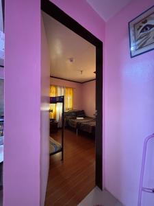 Habitación con paredes de color púrpura y habitación con cama en Maru Vibe Guest house at Panicsican San Juan Elyu, en San Juan