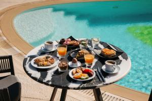 a tray of food on a table next to a pool at Kouros Art Hotel - Designed for Adults in Stelida