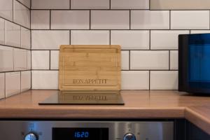 una scatola di legno appoggiata su un bancone accanto a una TV di Rosemont ApartHotel a Stanningley Altre 69 foto