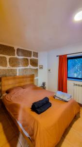 ein Schlafzimmer mit einem großen Bett mit zwei Kissen darauf in der Unterkunft Quinta Sarnadela - Spacious 3 bedroom house with mountain view in Oliveira do Hospital