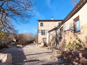 una antigua casa de piedra con una calle adoquinada en Mas Lloretó - La Oreneta, en Copóns 9 fotos más