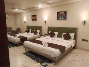 伯杰默里Hotel satpura inn的一间酒店房间，房间里有两张床 更多1张照片