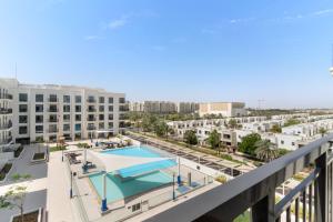 un balcone con vista sulla piscina. di VayK - Chic 2BR in Town Square with Pool View a ‘Ūd al Bayḑāʼ