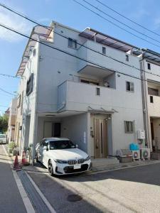 a white car parked in front of a building at hibiki hotel osaka in Osaka