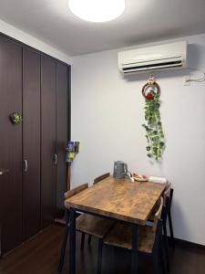 een eetkamer met een houten tafel en een airconditioning bij hibiki hotel osaka in Osaka +22 foto's
