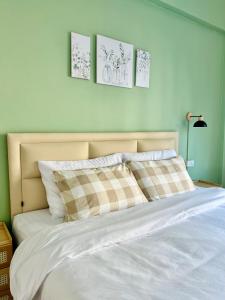 a bedroom with a white bed with three pictures on the wall at Calm Stay & Cafe in Chiang Mai