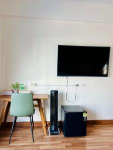 a room with a table and a television on a wall at Calm Stay & Cafe in Chiang Mai +13 photos