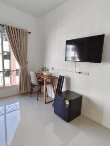 a living room with a table and a flat screen tv at Calm Stay & Cafe in Chiang Mai