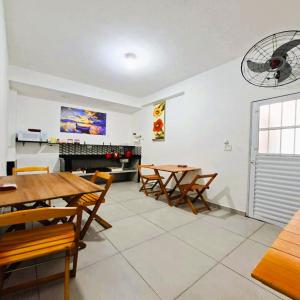 een eetkamer met houten tafels en stoelen bij Pousada Casa da Fernanda, Suíte Sun in Praia Grande