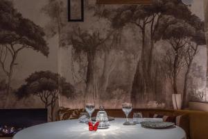 un tavolo con bicchieri da vino e un muro con alberi di Auberge De Saint-Rémy - Restaurant Gastronomique a Saint-Rémy-de-Provence