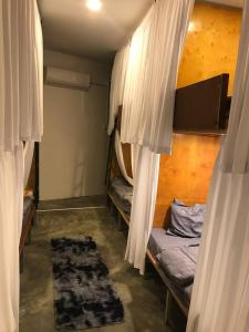 a room with two bunk beds with curtains and a rug at Reaksa Hostel & Spa - Koh Rong in Kaôh Rŭng (6)