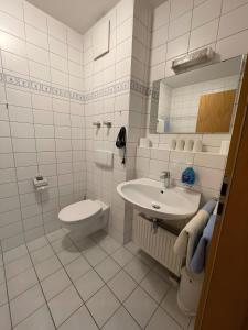 a white bathroom with a sink and a toilet at Ferienwohnung Alpenpanorama in Oberaudorf