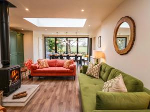 a living room with a green couch and a fireplace at Fairview in Saxmundham