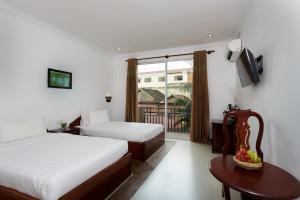 une chambre d'hôtel avec deux lits et une télévision dans l'établissement La Villa du Bonheur, à Siem Reap 57 autres photos