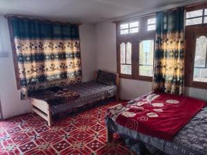 una stanza con due letti, un divano e finestre di Kalash Resort and camping side a Chitral