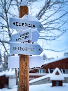 ムジャシフレにあるZespół Tatry - Hotel Tatry i Budynek Turystycznyの雪の中に立つ道路標識のついた木の柱 +109枚の写真