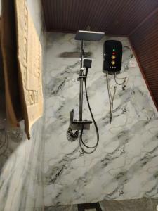 埃拉Mountain Face inn的一间铺着白色大理石地板的浴室，上面有一盏灯。