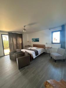 a bedroom with a bed and two chairs in it at Villa Groovy in Lajares +27 photos