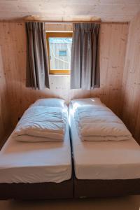 due letti in una piccola stanza con una finestra di Large Greenhouse op Boetiekpark de Kas a Scherpenzeel