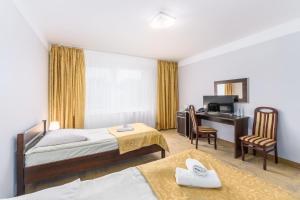 Centrum Rehabilitacyjno - Wczasowe Amber في كولوبرزيغ: غرفة فندقية بسريرين ومكتب