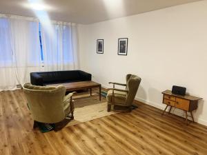 a living room with a couch and two chairs and a table at Emmas Apartments in Duisburg