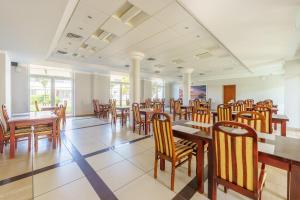 Centrum Rehabilitacyjno - Wczasowe Amber في كولوبرزيغ: غرفة طعام مع طاولات وكراسي خشبية