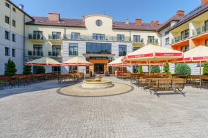 Centrum Rehabilitacyjno - Wczasowe Amber في كولوبرزيغ: ساحة مع طاولات وكراسي ونافورة