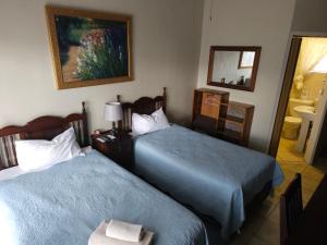 a hotel room with two beds and a mirror at Steendal Guest House in Polokwane +3 photos