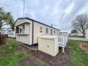 a tiny house is parked in a yard at Great 8 Berth Caravan For Hire At Seawick Holiday Park In Essex Ref 27227Sw in Clacton-on-Sea