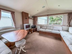a living room with a couch and a table at Great 8 Berth Caravan For Hire At Seawick Holiday Park In Essex Ref 27227Sw in Clacton-on-Sea