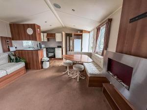 a living room with a table and a kitchen at Great 8 Berth Caravan For Hire At Seawick Holiday Park In Essex Ref 27227Sw in Clacton-on-Sea