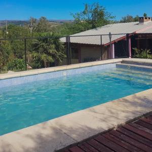 a swimming pool in front of a house at CABAÑAS SANTA RITA - Tanti, Córdoba in Tanti