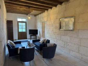 a living room with two blue couches and a tv at Le chene vert in Saint-Front-de-Pradoux